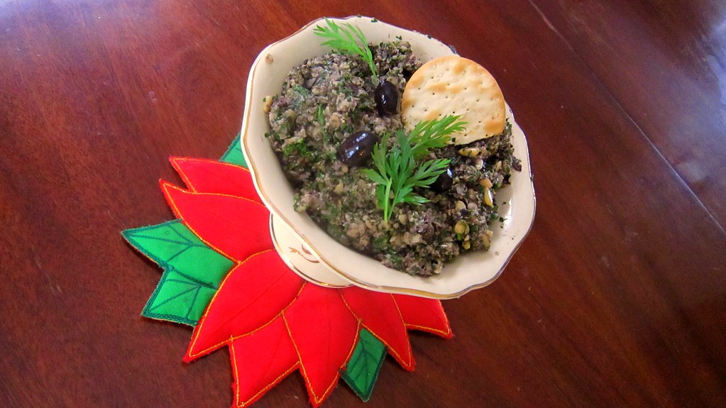 picture of a bowl of tapenade with garnish and cracker